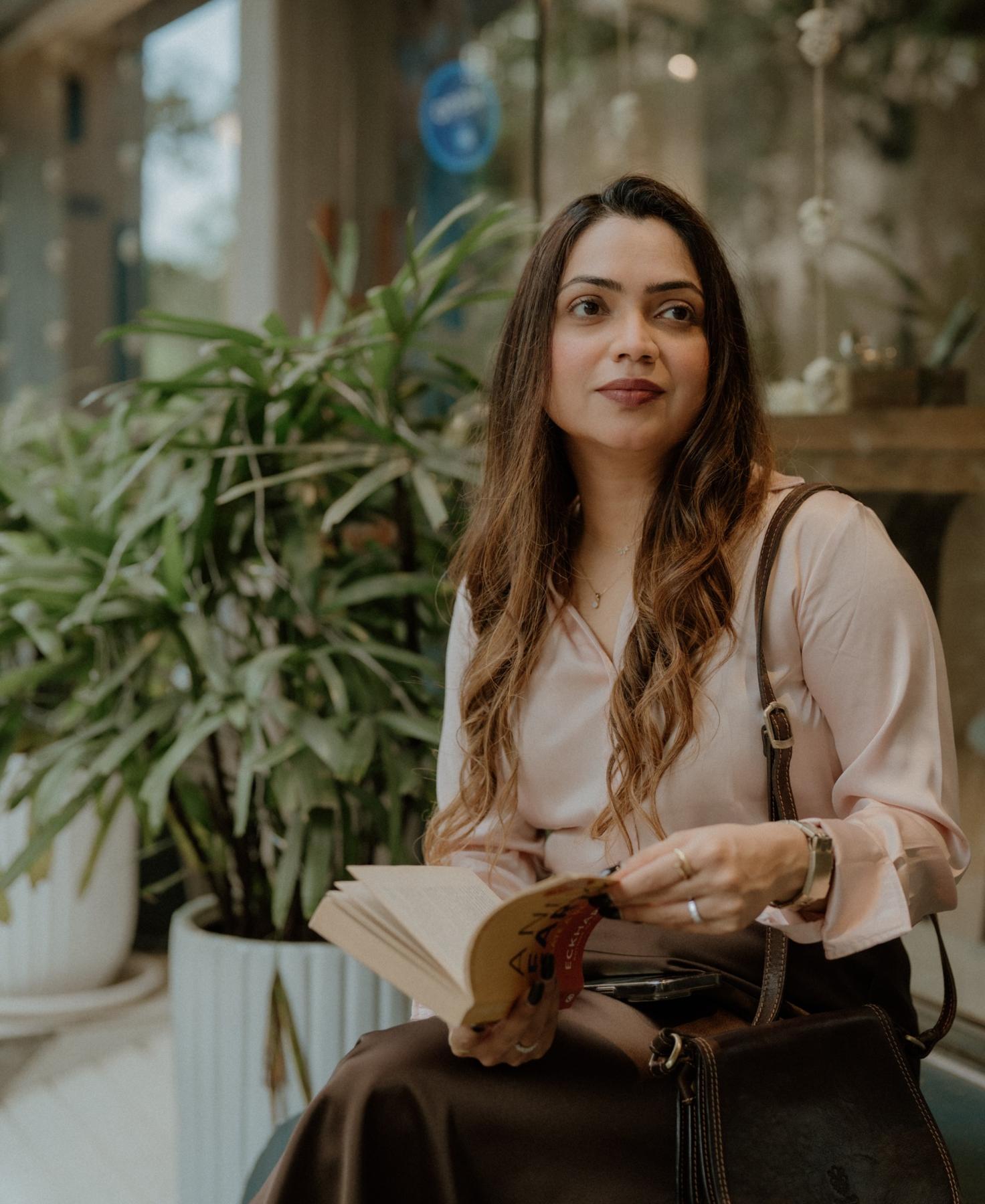 Ayaana Khapre holding a book in a garden café